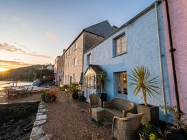 An outdoor seating area next to a house at Quay Cottage in 