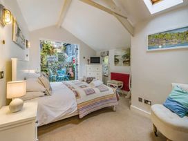 A bedroom with a bed and a view of the garden at Quay Cottage
