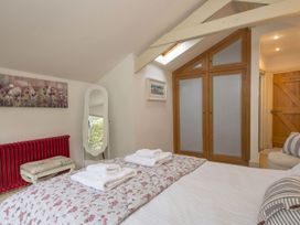 A bedroom with a bed, wardrobe, and mirror at Quay Cottage