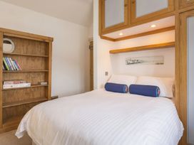 A bedroom with a bed and bookshelf at Quay Cottage