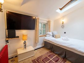A bedroom with a television and a single bed at Quay Cottage 