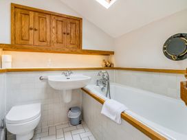 A bathroom with a sink, toilet, and bath at Quay Cottage