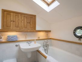 A bathroom with a sink and bath tub at Quay Cottage 