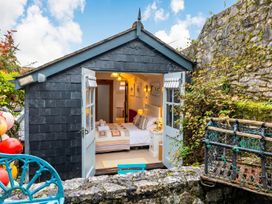 A bedroom with a double bed and windows at Quay Cottage 