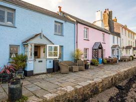 An outdoor area with colorful houses and furniture at Quay Cottage