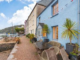 An outdoor area with tables and chairs at Quay Cottage