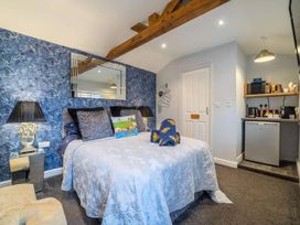 A bedroom with a bed and kitchenette at The Old Barn in Manchester