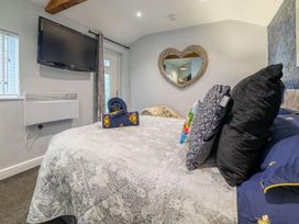 A bedroom with a bed, television, and mirror at The Old Barn in Manchester