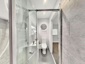 A bathroom featuring a shower, toilet, and sink with a mirror at the property in location