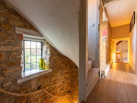 A hallway with a stone wall and a window at 