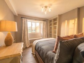 A bedroom with a bed, lamp, shelves, and curtains at 