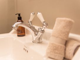 A sink with a faucet and towels at the bathroom