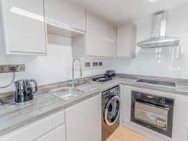 A kitchen with a sink, oven, and washing machine at the property