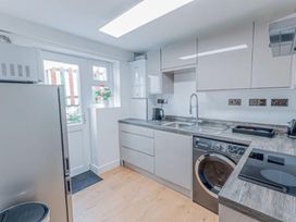A kitchen with appliances and work surfaces in a modern design at The Old Barn in Manchester