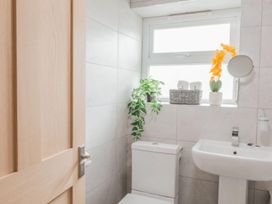 A bathroom featuring a toilet, sink, and window at The Old Barn in Manchester