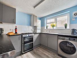 A kitchen with a wine bottle and loaf of bread at The Old Barn in Manchester