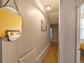 A hallway with a mirror, lamp, and radiator at 