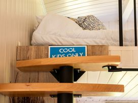 A bedroom with a bed and a sign saying COOL KIDS ONLY