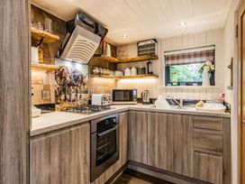 A kitchen with appliances and wooden shelves at The Old Barn in Manchester