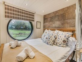 A bedroom with a round window and a bed at the property