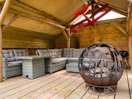 An outdoor seating area with a sofa, table, fire pit, and model airplane at 