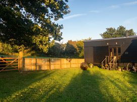 An outdoor area with a wooden gate and a black house at an unspecified location