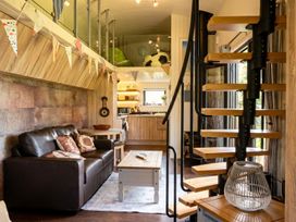 A living room with a sofa, coffee table, and spiral staircase at the property