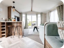 A living room with a kitchen island and bar stools at Brookwood Willerby, 36 bay view in Filey