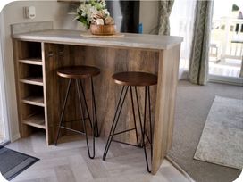 A kitchen bar with two stools and shelves at Brookwood Willerby, 36 bay view, Filey