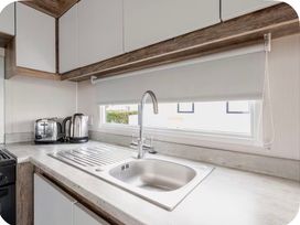 A kitchen with a sink and appliances at Brookwood Willerby, 36 bay view, Filey