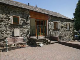 An outdoor area with a stone building and a wooden bench at Swallow's Nest in Keswick