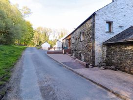 An outdoor area with a stone house and paved road at Swallow's Nest in Keswick