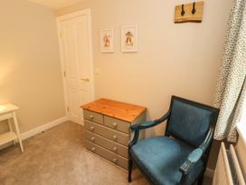 A bedroom with a chair and dresser at Swallow's Nest in Keswick