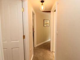 A hallway with doors and a light fixture at Swallow's Nest in Keswick