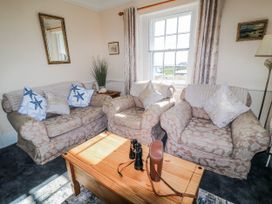 A living room with sofas and a coffee table at Old Higher Lighthouse Stopes Cottage Portland Bill