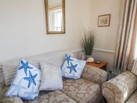 A living room with a sofa and cushions at Old Higher Lighthouse Stopes Cottage in Portland Bill
