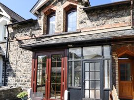 A stone building with two arched windows and wooden framed glass doors at 3 Railway Cottages in Betws-y-Coed