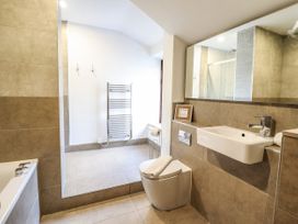 A bathroom with a bathtub toilet sink towel rack and large mirror at 3 Railway Cottages in Betws-y-Coed