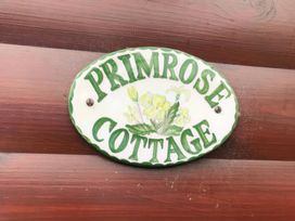 A nameplate for Primrose Cottage displayed on a wooden surface at Primrose Lodge in Saltburn-by-the-Sea