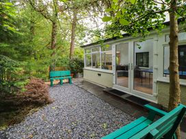 A garden with a green bench and gravel pathway at Eden House in Bardsea