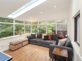 A conservatory with a sofa and windows at Eden House in Bardsea