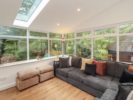 A conservatory with large windows and a sofa at Eden House in Bardsea