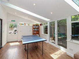A snug with a ping pong table and bookshelves at Eden House Bardsea
