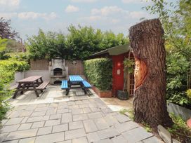 A garden with tables and a barbecue at Eden House in Bardsea