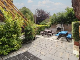 A garden with seating and a barbecue at Eden House in Bardsea