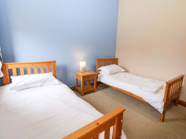 A bedroom with two beds and a nightstand at Pottowe Cottage in Potto near Stokesley