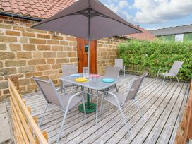 A deck with a table and chairs at Pottowe Cottage in Potto near Stokesley
