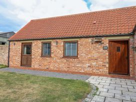 A brick exterior with windows and doors at Cooper Cottage in Potto near Stokesley