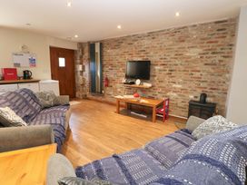 A living room with two sofas and a television at Cooper Cottage in Potto near Stokesley