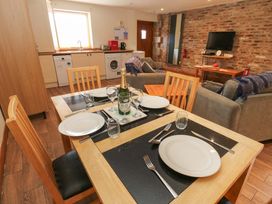 A dining area with a table set for a meal at Cooper Cottage in Potto near Stokesley